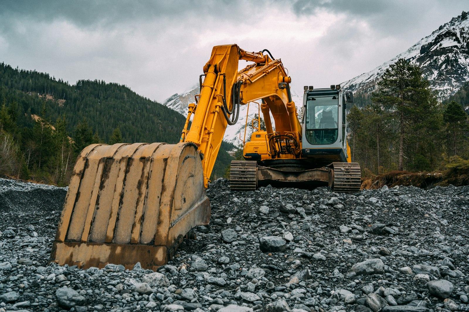 Excavadora amarilla trabajando en terreno rocoso